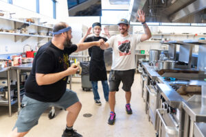 2025 Culinary Excelerator Instructors and Youth fist bumping