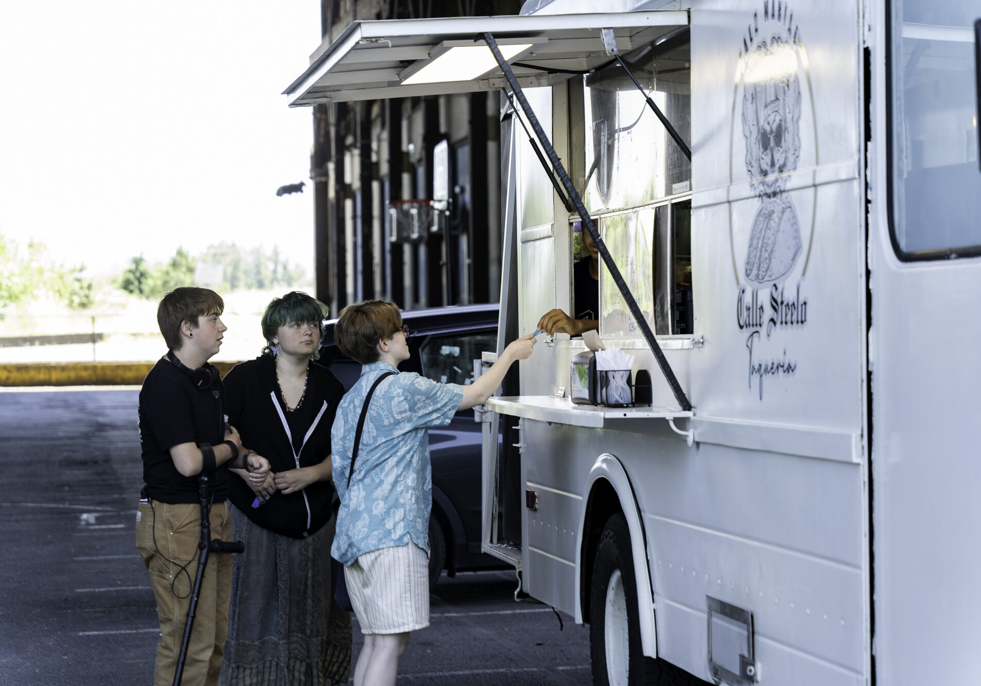 Three youth getting food from a food truck at Bonanza at Booth-Kellyy